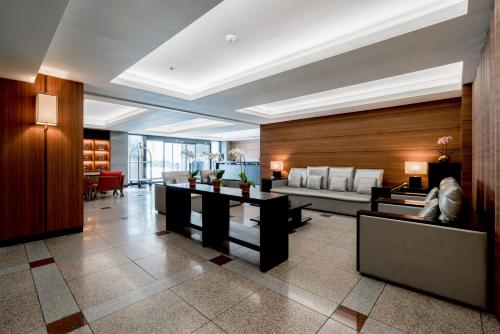 a lobby with couches and tables in a building at Oriens Hotel & Residences Myeongdong in Seoul