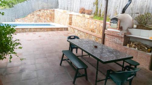 een patio met een tafel en stoelen en een buitenoven bij Casa Rural Los Caballos Finca Canca Alora Caminito del Rey in Alora