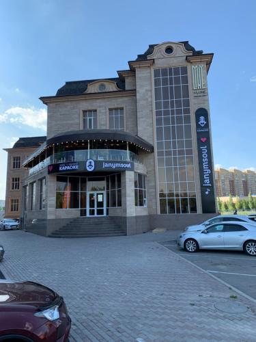a building with cars parked in front of it at MyLINE relax complex in Astana