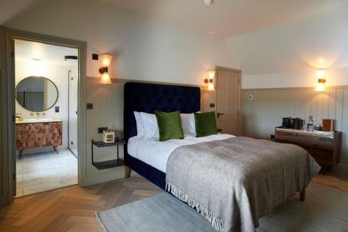 1 dormitorio con 1 cama grande y baño en The Ingham Swan, en Stalham