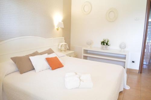 una camera con un letto bianco con due cuscini di Hotel Relais Antica Masseria a Turi