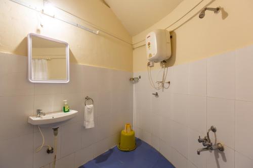 a bathroom with a sink and a mirror at KSTDC Hotel Mayura Krishna Almatti in Bāgalkot