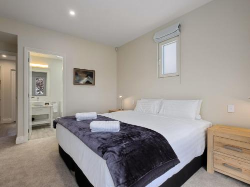 a bedroom with a large bed with two towels on it at Stonehill Villa - 5 Bed in Queenstown