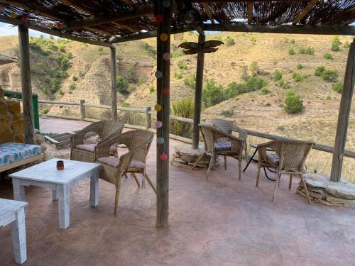 a patio with tables and chairs and a view of a hill at Casa Rural Rio Chicamo in La Umbría