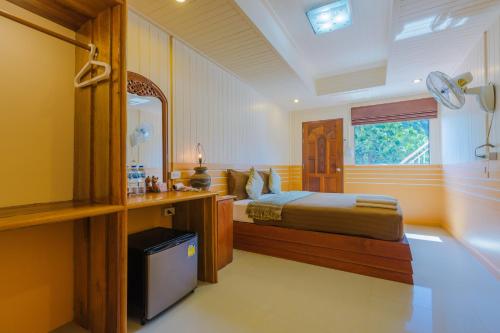 1 dormitorio con cama, escritorio y ventana en Railay Hilltop en Railay Beach