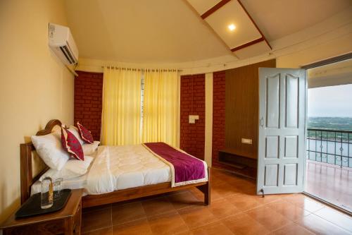 a bedroom with a bed and a balcony at KSTDC Hotel Mayura Krishna Almatti in Bāgalkot