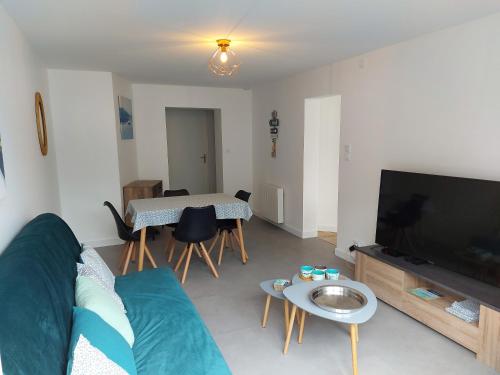 un salon avec un canapé, une télévision et une table dans l'établissement Choletais forever..., à Cholet