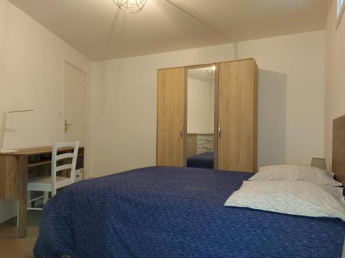 une chambre avec un lit bleu et un miroir dans l'établissement Choletais forever..., à Cholet
