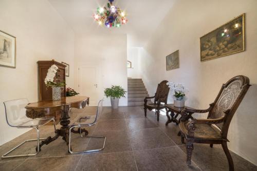 a living room with chairs and a table and a chandelier at Casa Guarnieri in Feltre