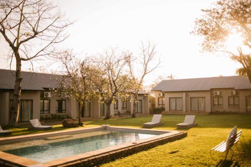 a swimming pool in the yard of a house at Hamiltons Lodge & Restaurant in Malelane