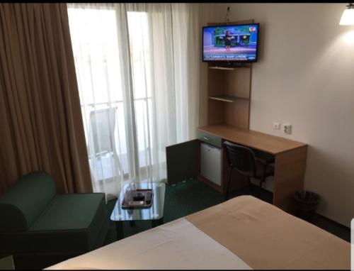a hotel room with a bed and a desk and a television at Delta Palace in Sulina