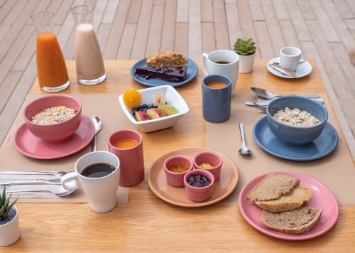 a table topped with plates of food and cups of coffee at Naturena Agro-Turismo in Durrães