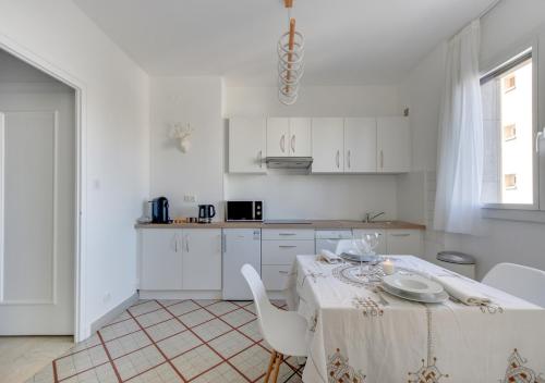 une cuisine blanche avec une table et des chaises blanches dans l'établissement Fauriel Aimé, à Saint-Étienne