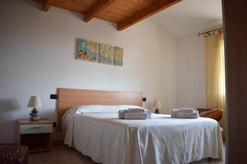 - une chambre avec un lit et 2 serviettes dans l'établissement COSTA DEL SINIS, à Cabras