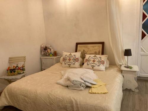 Una cama con sábanas blancas y almohadas en un dormitorio en MY HOME SCARPERIA, en Scarperia