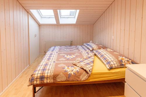 Cet appartement comprend une chambre dotée d'un lit et d'une lucarne. dans l'établissement Ferienwohnung & Studio Schaad, à Hasliberg Wasserwendi