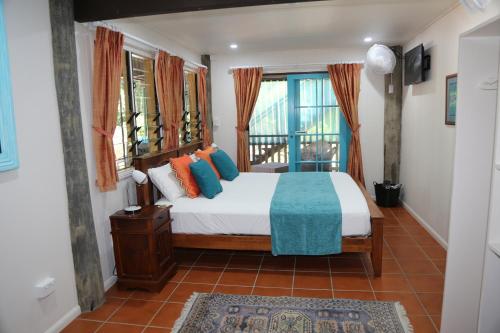 1 dormitorio con cama y ventana en Licuala Lodge, en Mission Beach