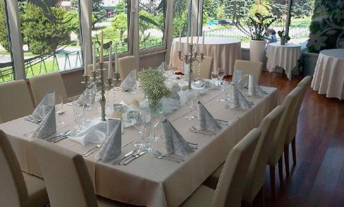 a long table with white table cloth and silverware at Hotel Šariš in Bardejov