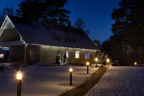 uma casa com luzes na neve à noite em Seedri Guesthouse em Võru