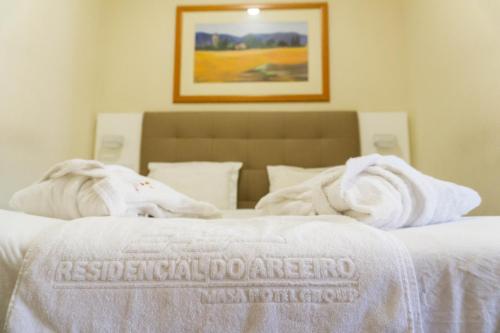 a bed with a white comforter and pillows on it at Residencial do Areeiro in Lisbon