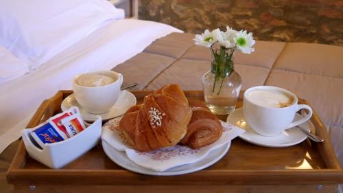a tray with two cups of coffee and pastries on a bed at Casa Di Campagna In Toscana in Sovicille