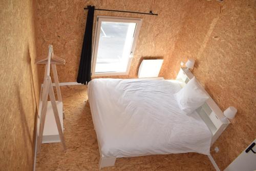 a bedroom with a white bed and a window at Gîte Esprit loft in Macau