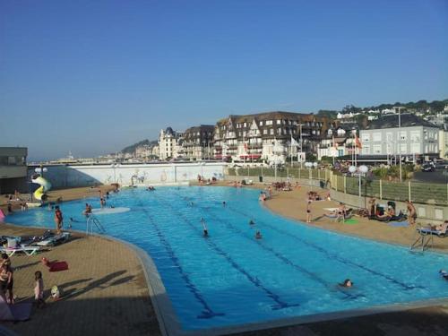une grande piscine avec des personnes sur une plage dans l'établissement Un chez soi bord de mer, à Trouville-sur-Mer