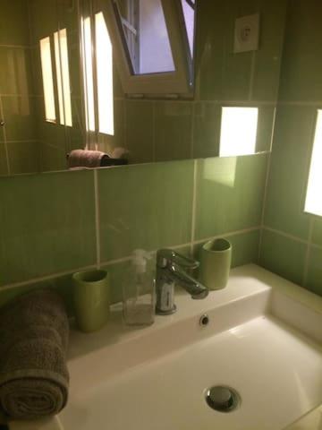 - un lavabo avec 2 tasses vertes et un miroir dans l'établissement Un chez soi bord de mer, à Trouville-sur-Mer