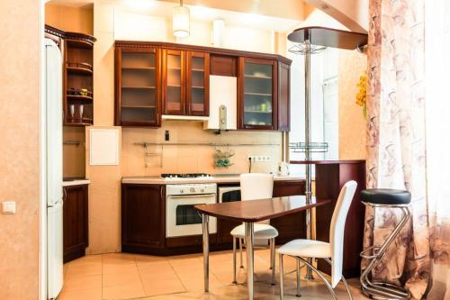 - une cuisine avec une table, des chaises, une cuisinière et des armoires dans l'établissement Large apartment in the center, à Dnipro