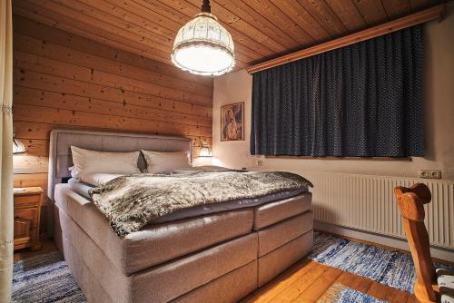 a bedroom with a bed and a chandelier at Appartements Zugspitztraum in Ehrwald