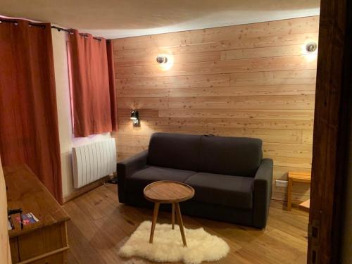 a living room with a black couch and a table at Mottaret in Méribel