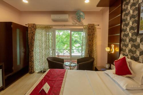 a bedroom with a bed and a table with chairs at KSTDC Hotel Mayura Riverview Srirangapatna in Seringapatam