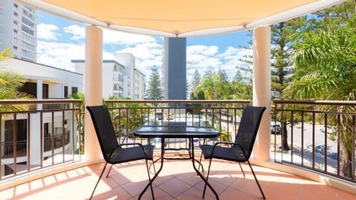 a patio with a table and chairs on a balcony at Burleigh on the Beach in Gold Coast