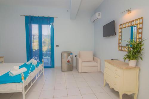 a bedroom with a bed and a chair and a mirror at Akrotiri in Vasiliki