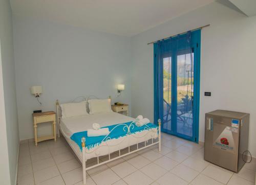 a bedroom with a bed with a blue door at Akrotiri in Vasiliki