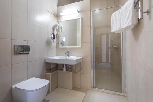 a bathroom with a toilet and a sink and a shower at Baza Otdykha Kazaki in Aleksandrovka