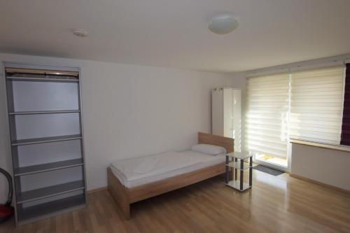 Kleines Zimmer mit einem Bett und einem Fenster in der Unterkunft Apartment Ostfildern in Ostfildern