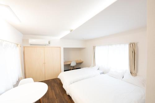 two beds in a room with white furniture at B&B MIKAWA 2 - Kanazawa Fish Harbour in Kanazawa
