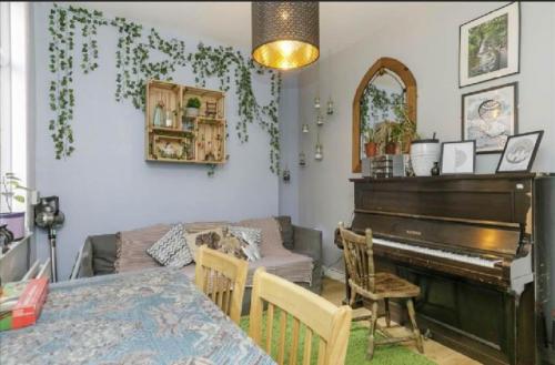 a living room with a table and a piano at Big Yellow Door in Queens Quarter in Belfast
