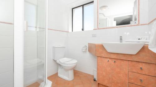 a bathroom with a toilet and a sink and a mirror at Burleigh on the Beach in Gold Coast