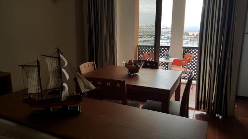 jadalnia z drewnianym stołem z modelem statku w obiekcie Marina Apartment w mieście Quarteira