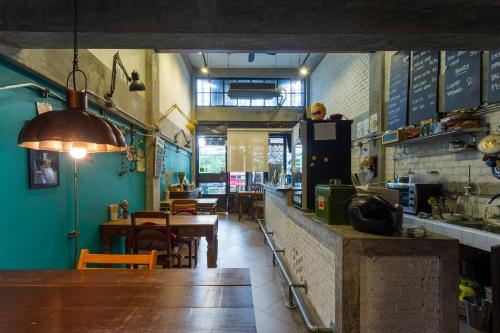 a restaurant with a table and a kitchen and a dining room at Box Hostel N Cafe in Chiang Mai
