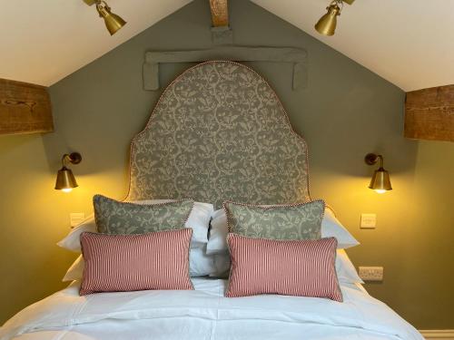 ein Schlafzimmer mit einem großen Bett mit zwei Kissen in der Unterkunft Bailey Cottage in Gargrave