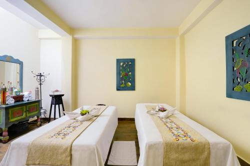 two beds in a room with white walls at The Fern Denzong Hotel & Spa Gangtok, Sikkim in Gangtok
