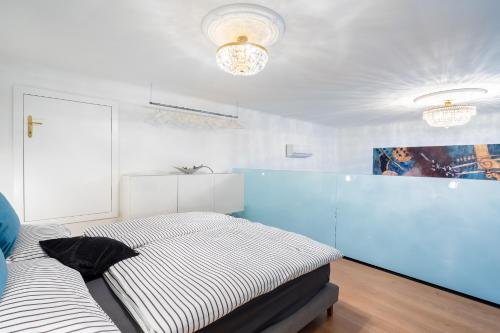1 dormitorio con 2 camas y pared azul en The Music - Luxuriöses City Loft am Naschmarkt en Viena