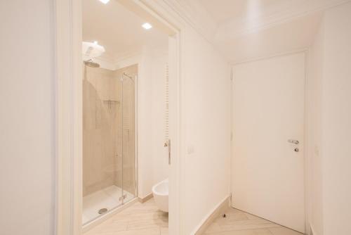 a white bathroom with a shower and a toilet at Hotel Marina Charming Rooms in Finale Ligure