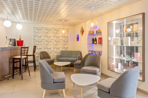 a waiting room with chairs and tables and a counter at Sure Hotel by Best Western Reims Nord in Reims