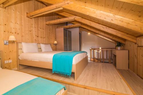 a bedroom with two beds in a room with wooden walls at Grand TheoNi Boutique Hotel & Spa in Vasiliki