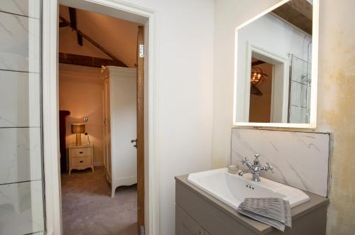 a bathroom with a sink and a mirror at Thirley Cotes Farm Cottages in Scarborough