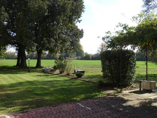 a garden with trees and a grass field at Corte Isolo in Goito